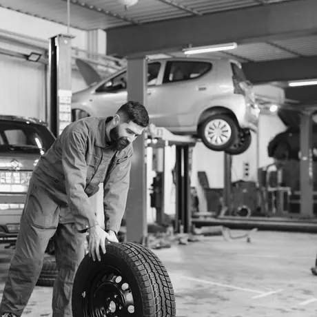 Mechaniker bringt ein Rad durch die Werkstatt